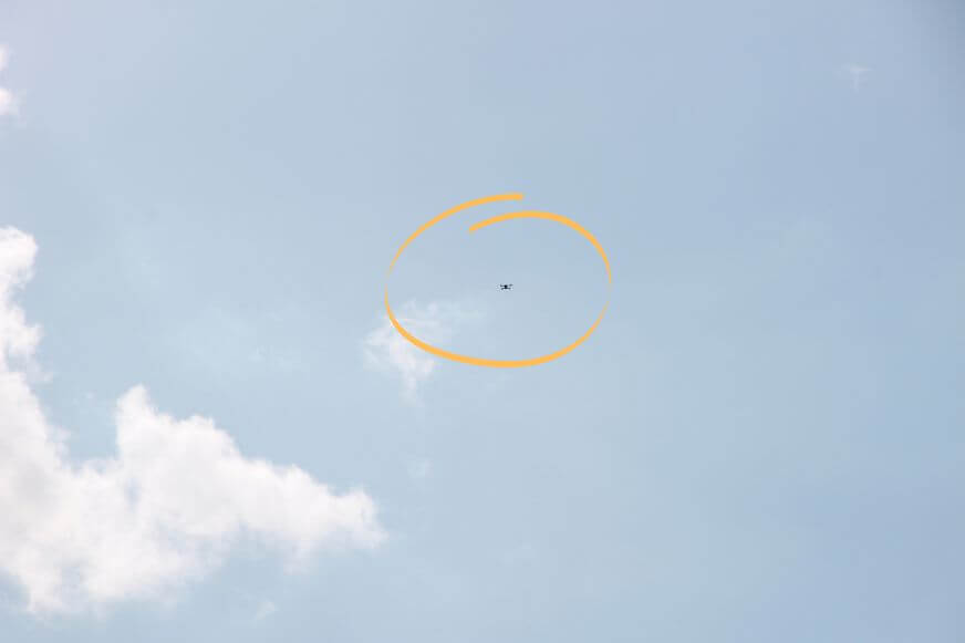 Die DJI Mavic 3 Drohne fliegt in ca. 50 Meter Höhe und ist bereits kaum sichtbar